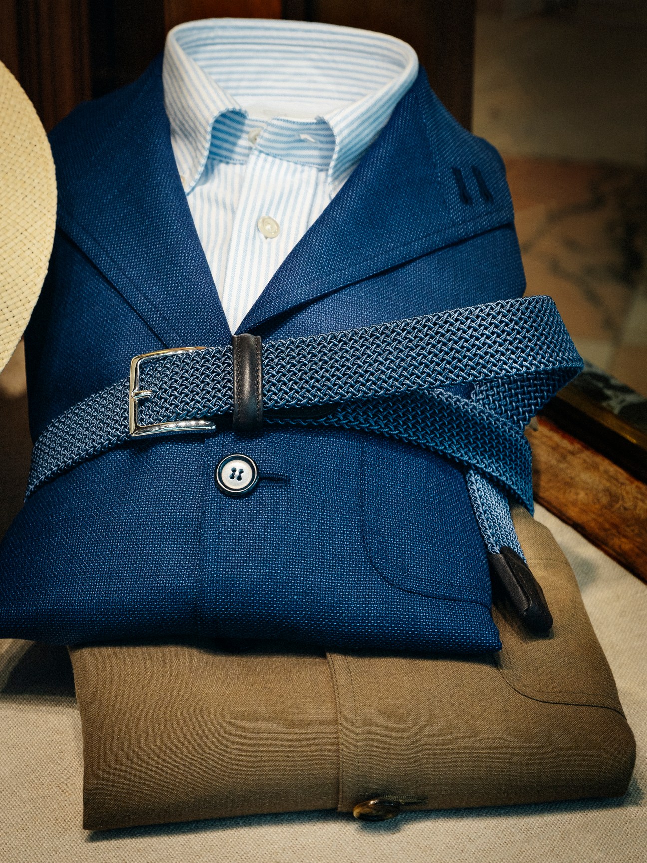 Blue blazer with striped shirt and woven belt displayed on mannequin