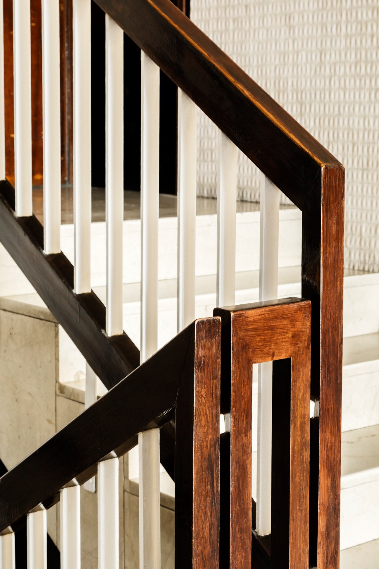 Modern stairway with dark wooden handrail and white vertical balusters in Melilla 31.