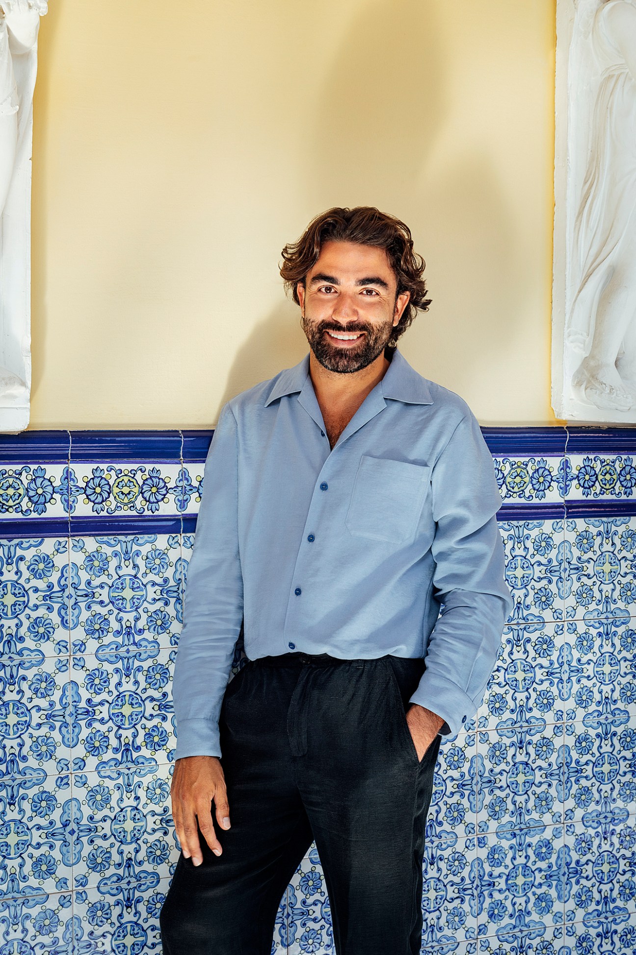 Concéntrico director Javier Peña Ibáñez standing against decorative blue and white tiled wall