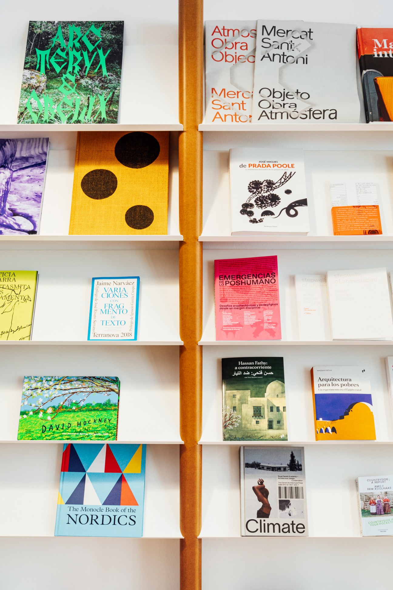 White bookshelf displaying colorful magazines and books including David Hockney and Nordic titles