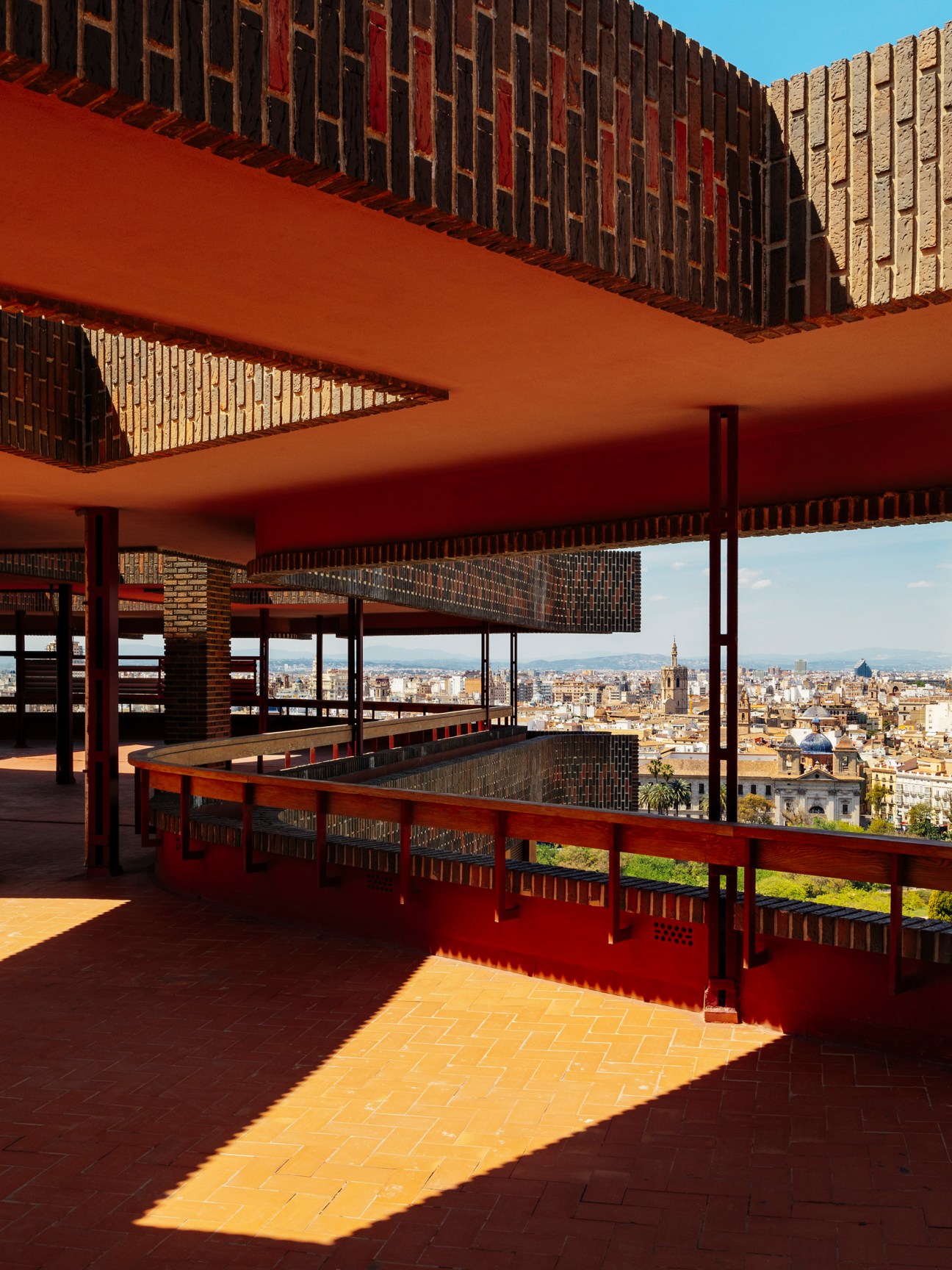Rooftop terrace with brick walls, wooden railings and panoramic views over Valencia's historic cityscape