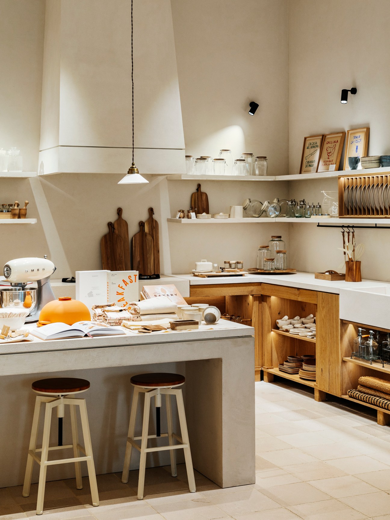 Modern kitchen interior with white countertops, wooden elements, open shelving, and pendant lighting