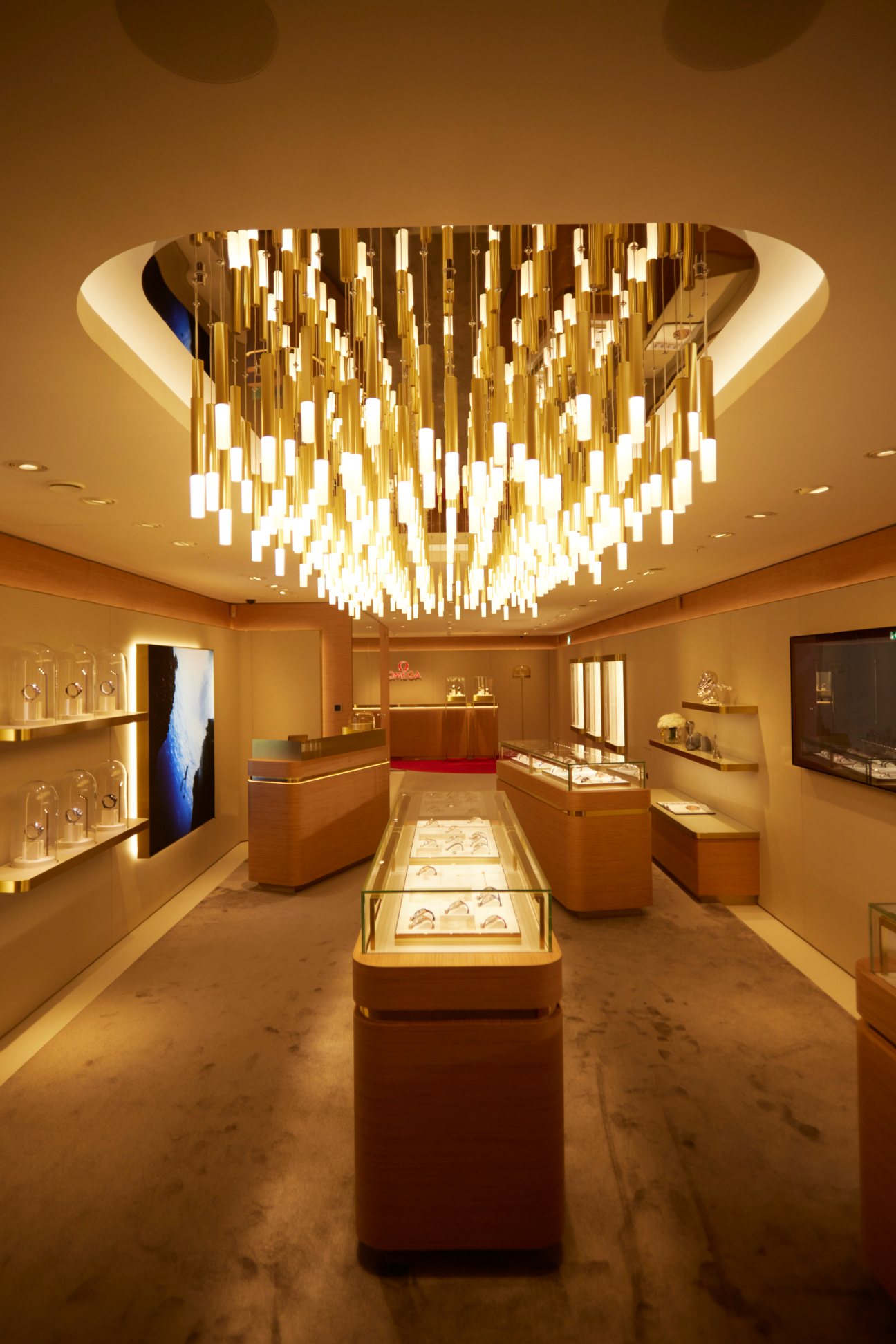 Luxury watch retail interior with dramatic golden ceiling installation and illuminated display cases