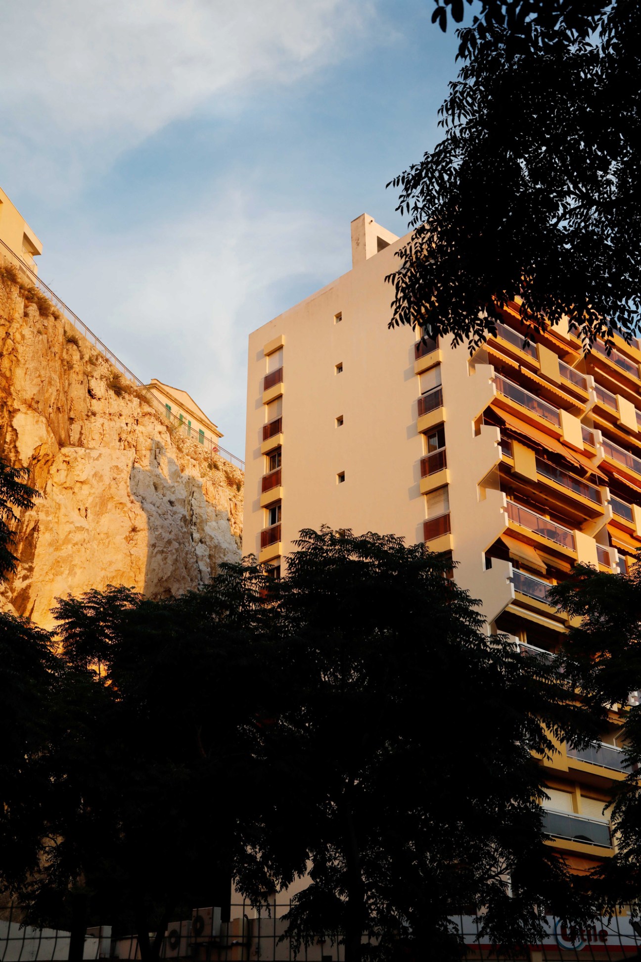 Modern apartment building facades glowing golden in warm evening light at sunset