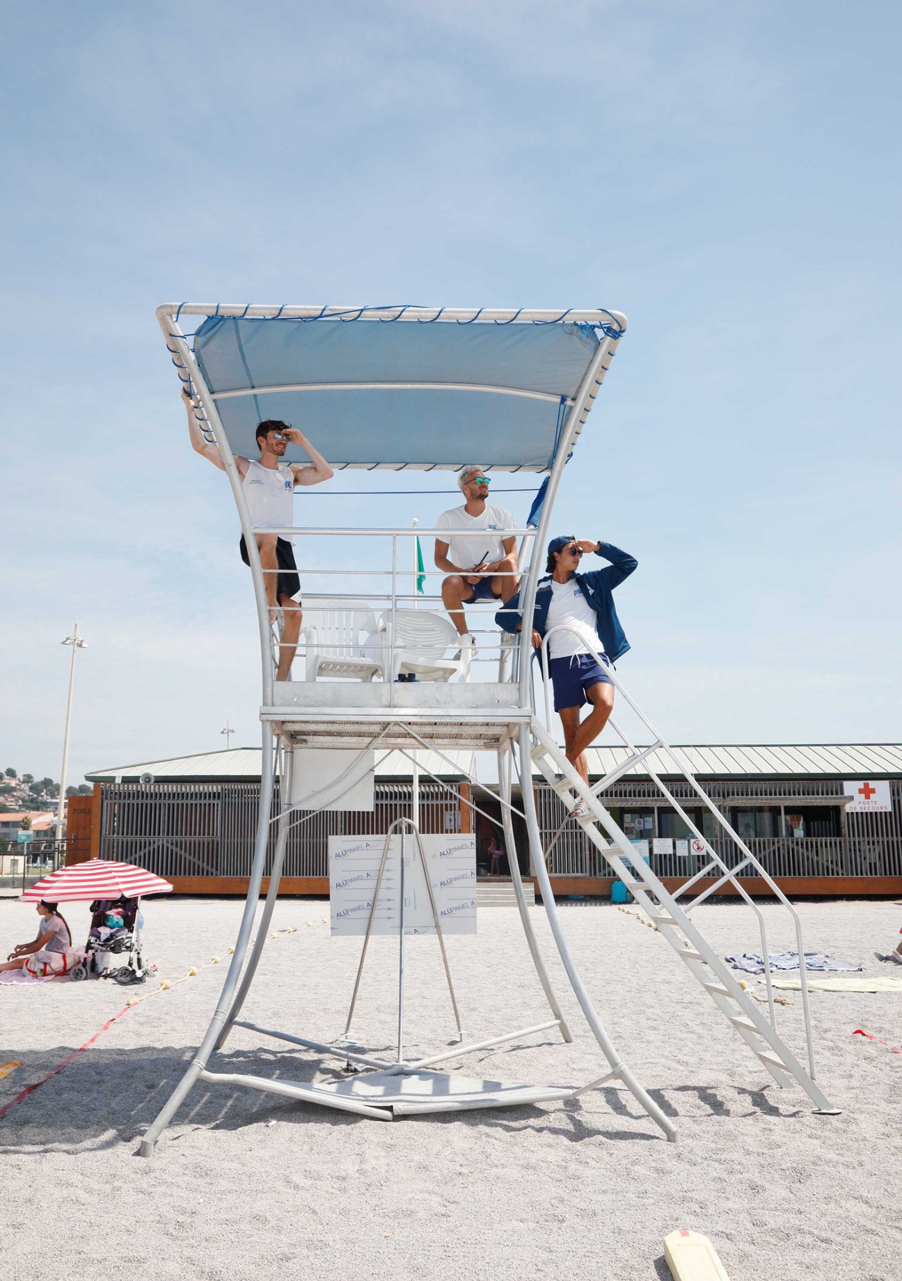Lifeguards sitting on elevated chairs watching beach and sea for swimmer safety