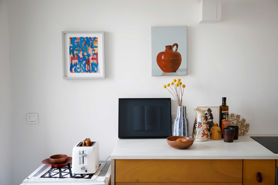 Modern kitchen interior with clean white surfaces, wooden cabinetry, and contemporary appliances