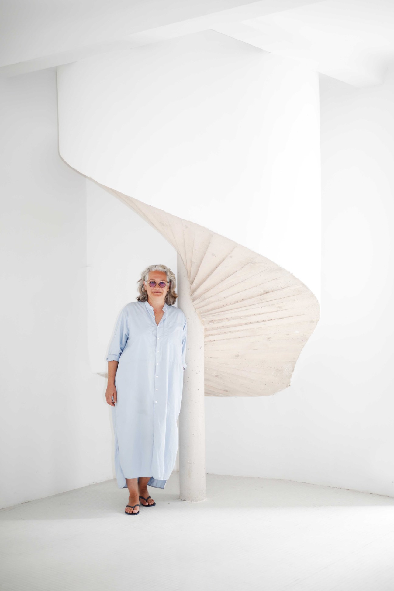 Catherine Bastide, gallerist and founder of La Traverse, standing against white architectural backdrop