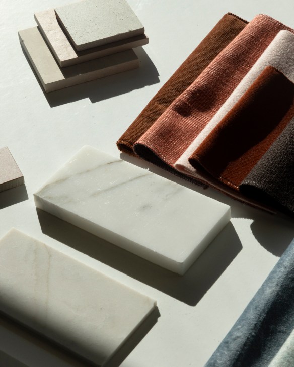 Collection of material samples including wood pieces, metal fragments, and fabric swatches arranged on a white surface