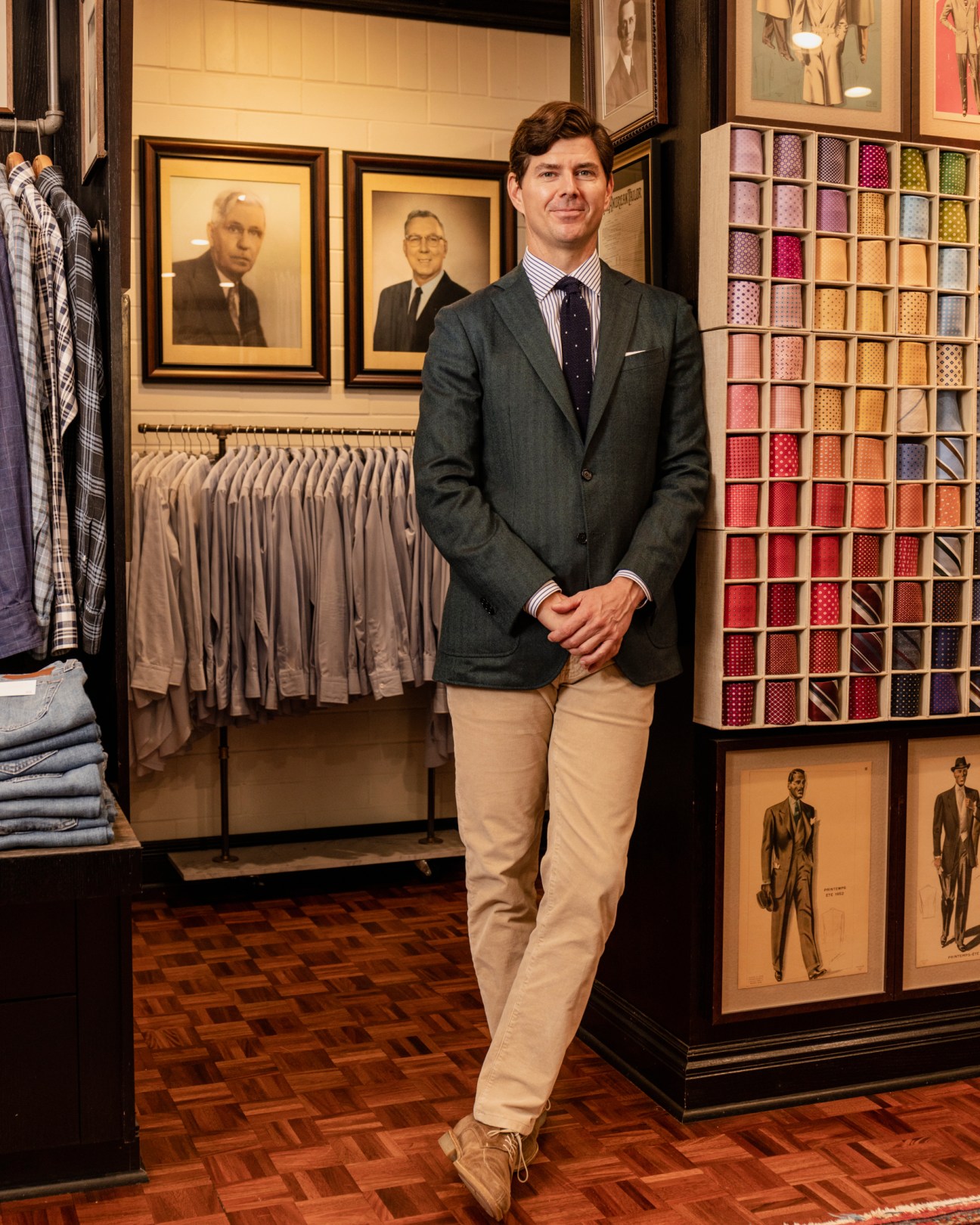 David Hamilton standing in a clothing store beside framed portraits on the wall