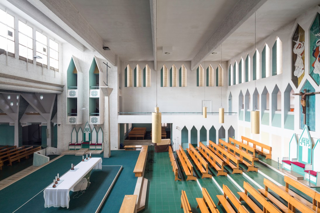 Interior of Gio Ponti's Concattedrale Gran Madre di Dio in Taranto showing wooden pews and teal architectural details