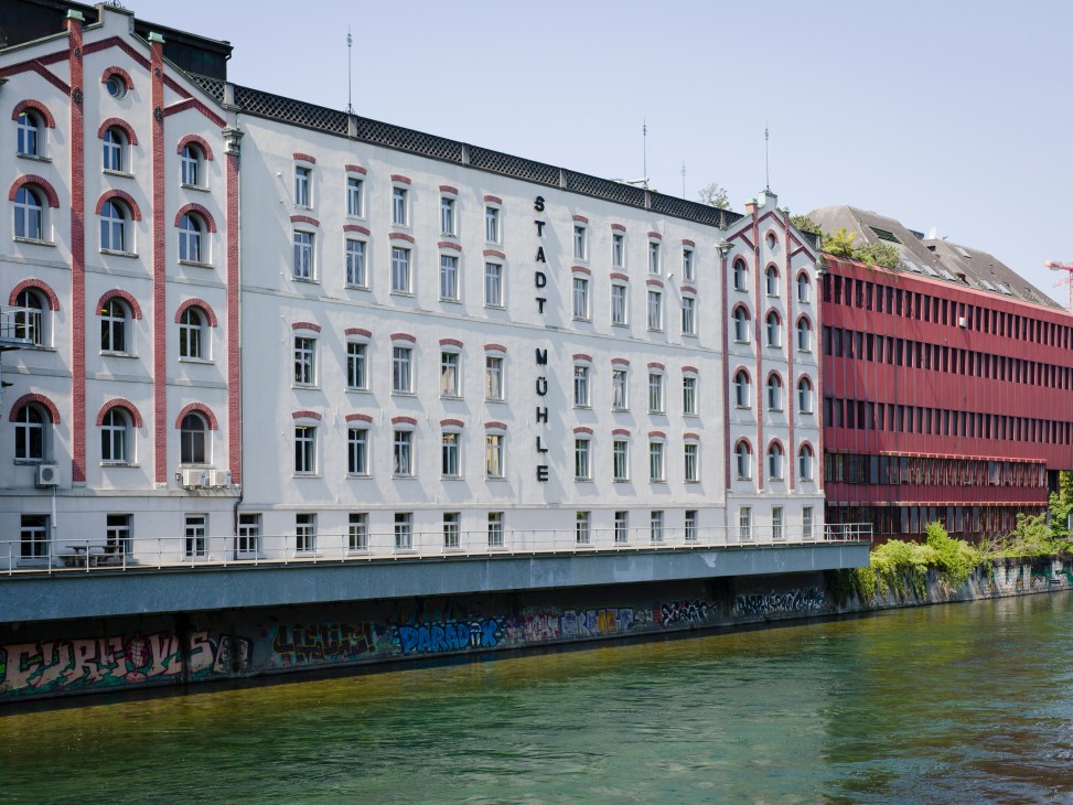 Historic riverside buildings in Vienna with white and red brick architecture reflected in the Danube Canal