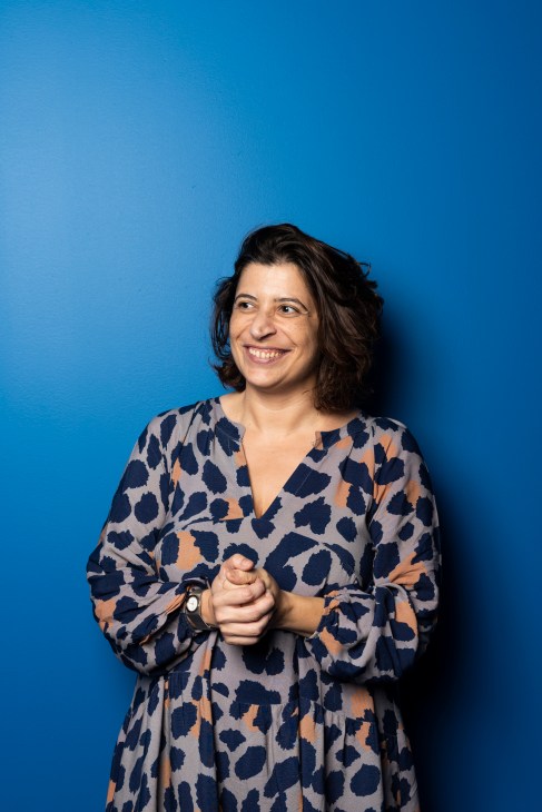 Judite França, host at Rádio Observador, smiling against a blue background.