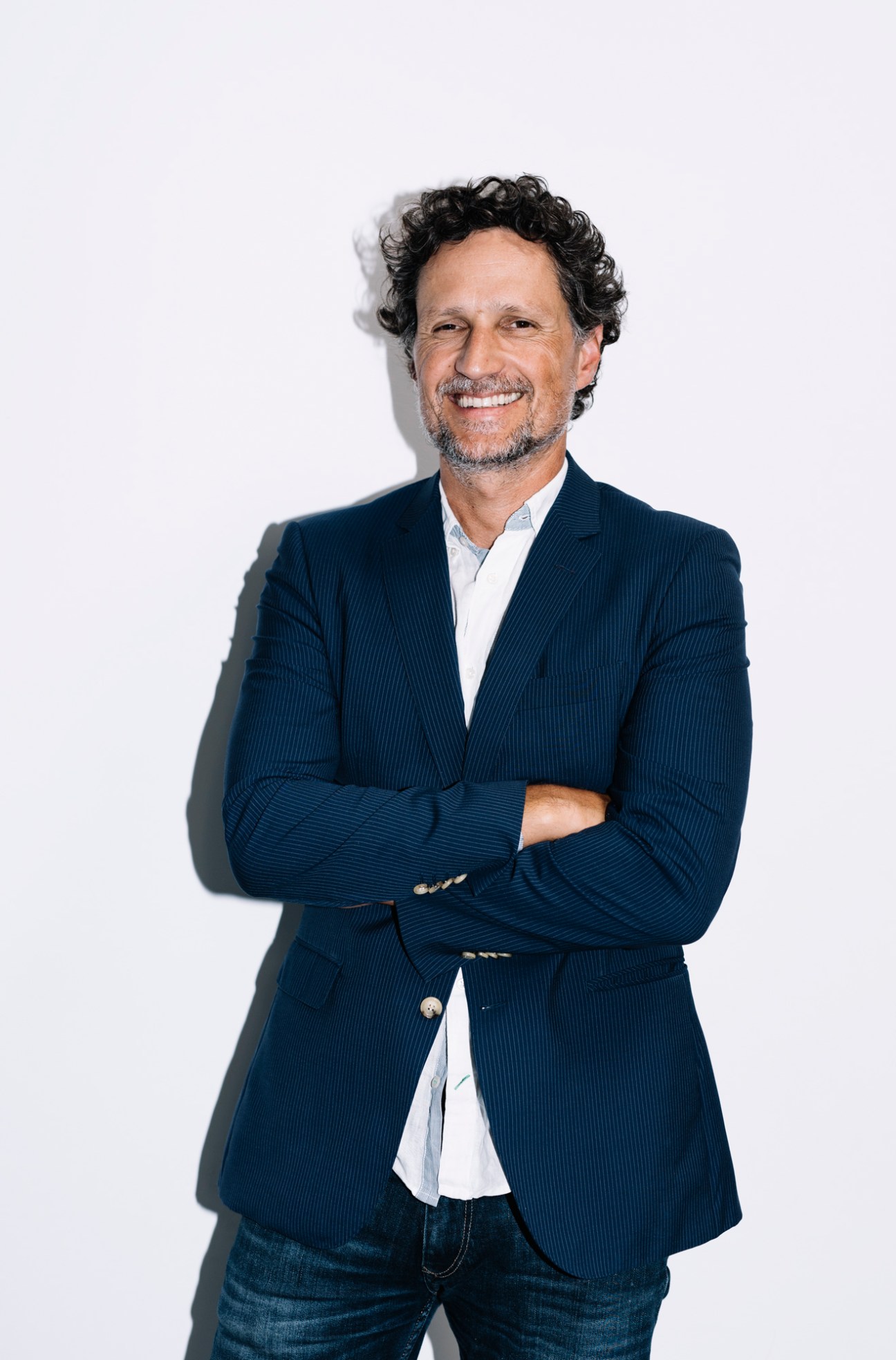 João Vieira Pereira of 'Expresso' newspaper standing with arms crossed in dark blazer
