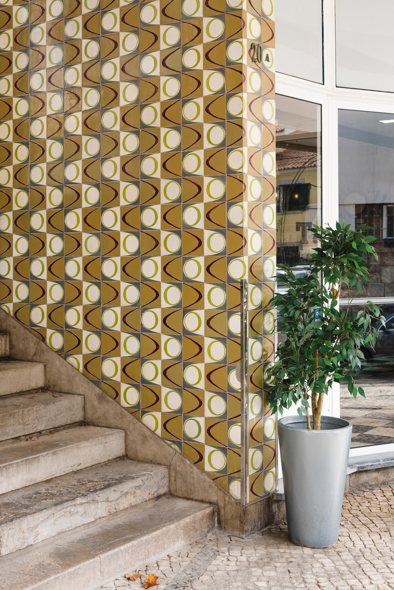 Geometric patterned tiles with brown, white and cream circular motifs on a building facade