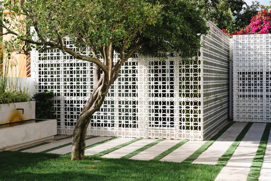 White decorative concrete block fence with geometric circular pattern in modern residential setting