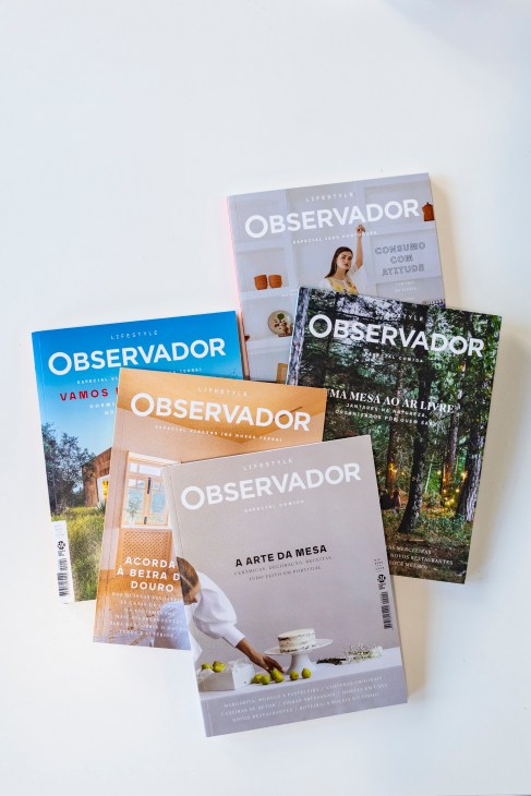 Stack of Observador Lifestyle quarterly magazines with various cover designs and themes.