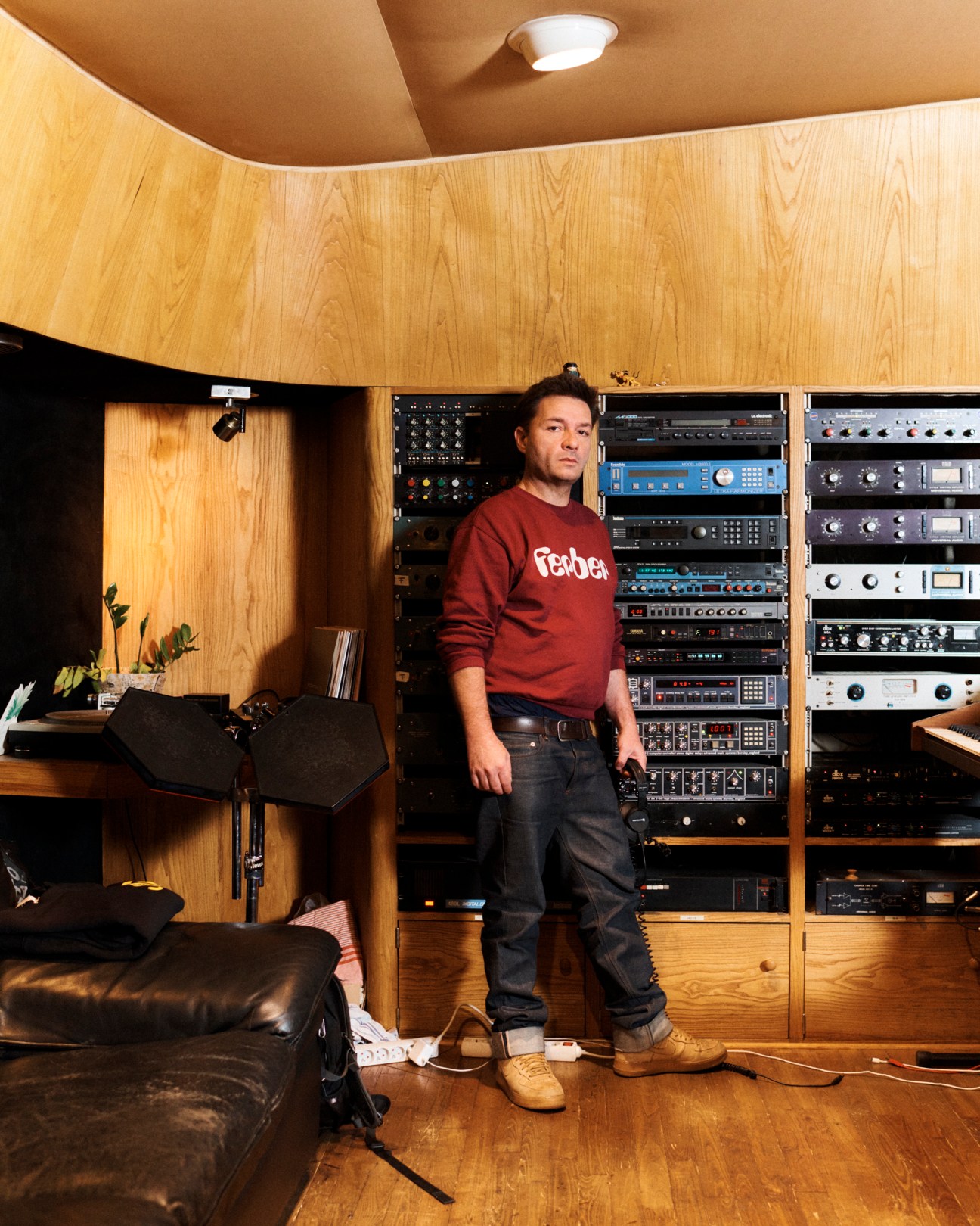 Renaud Letang standing in his wood-panelled recording studio surrounded by professional audio equipment