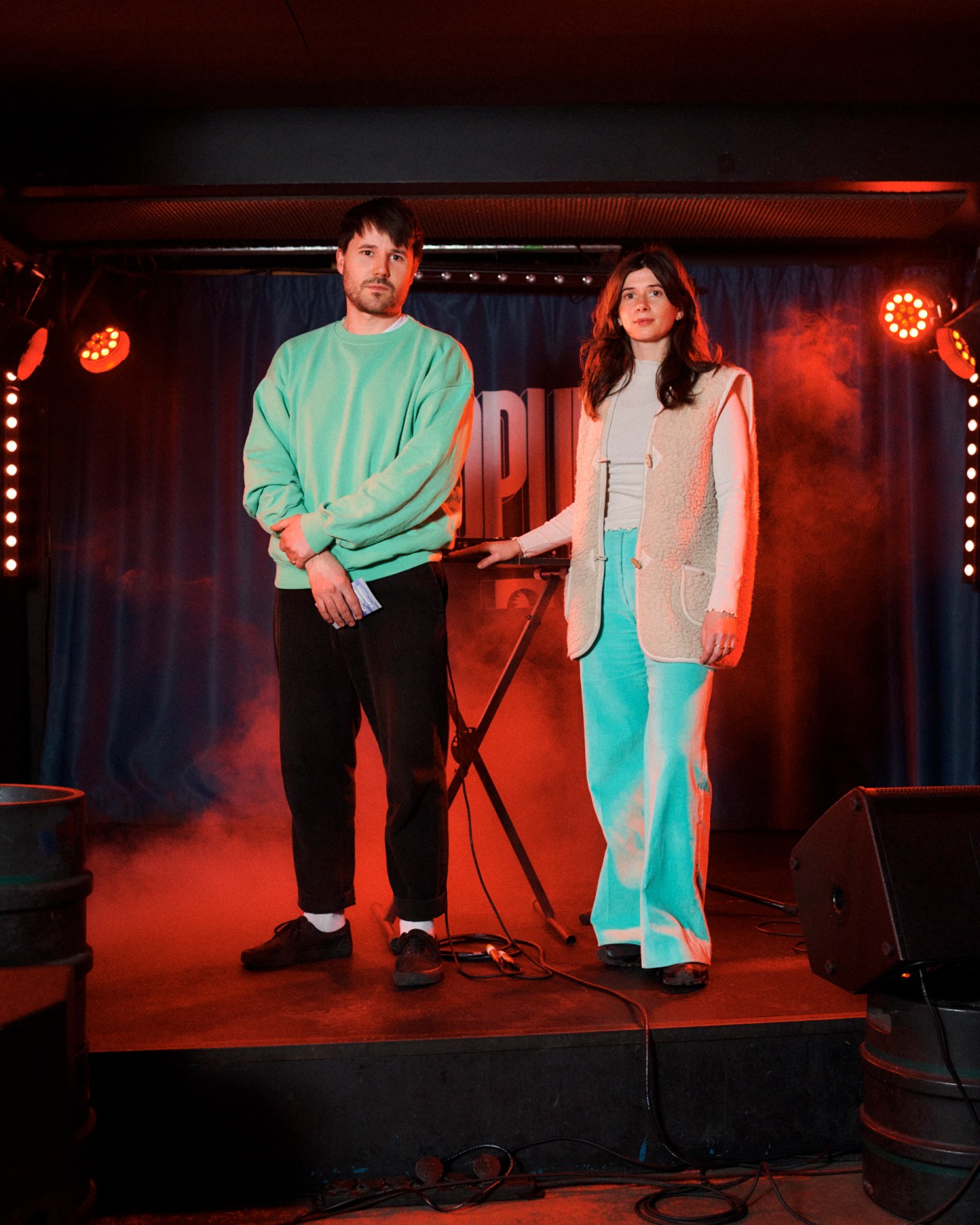 Louis Dumas and Pauline Couten standing on stage at Le Popup venue with colorful lighting