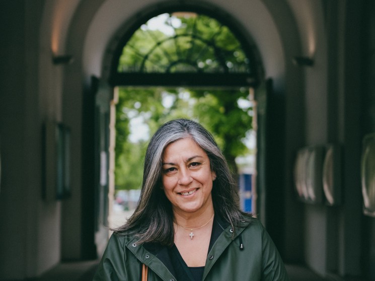 Maria Vassilakou standing in an arched passageway wearing a green coat