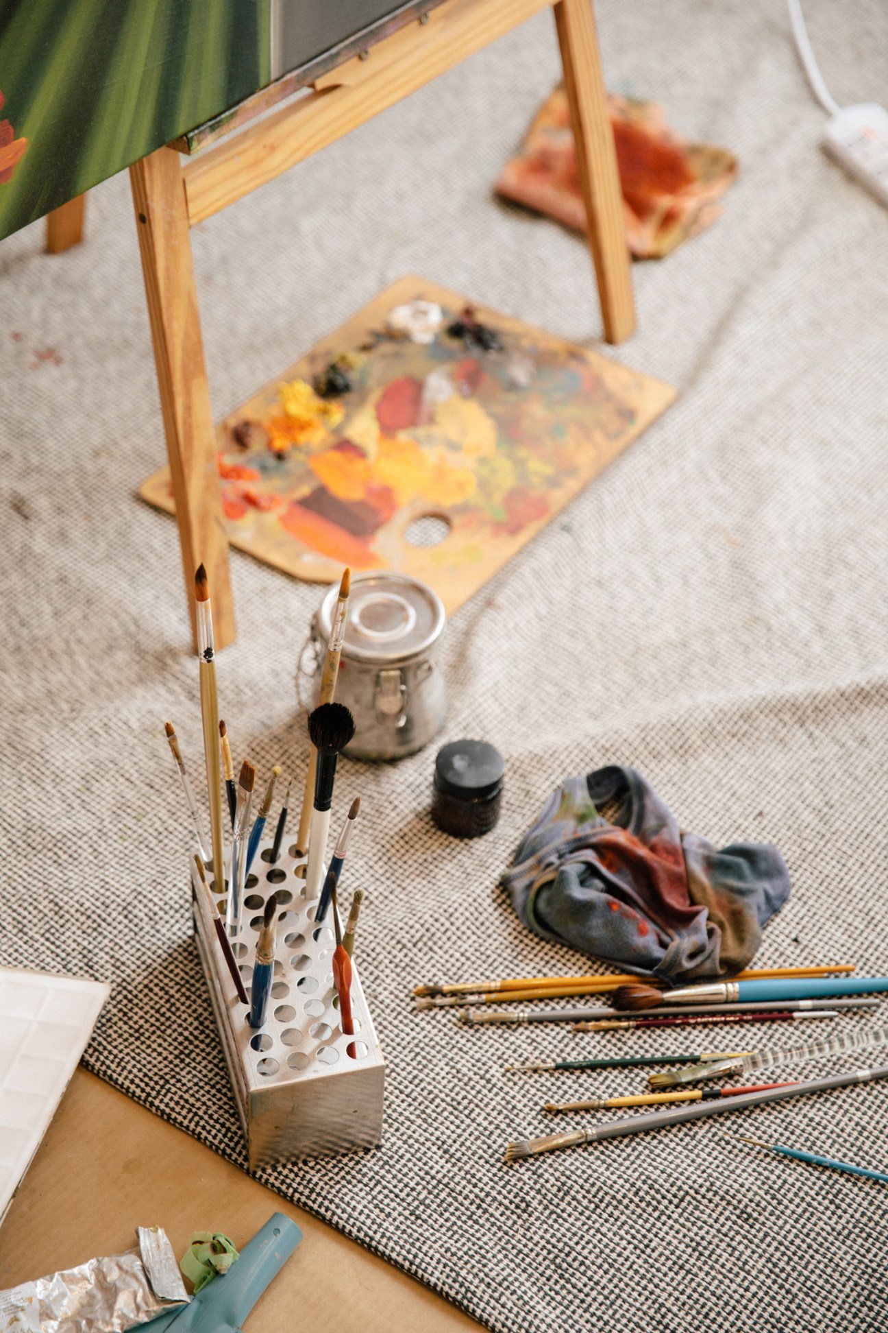 Close-up of paintbrushes and art supplies arranged in Ridhwan's studio workspace