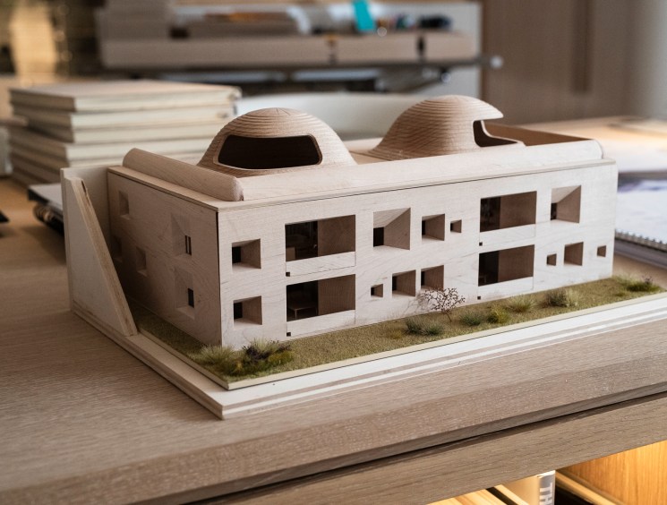 Architectural scale model of a building with domed roofs on a desk.