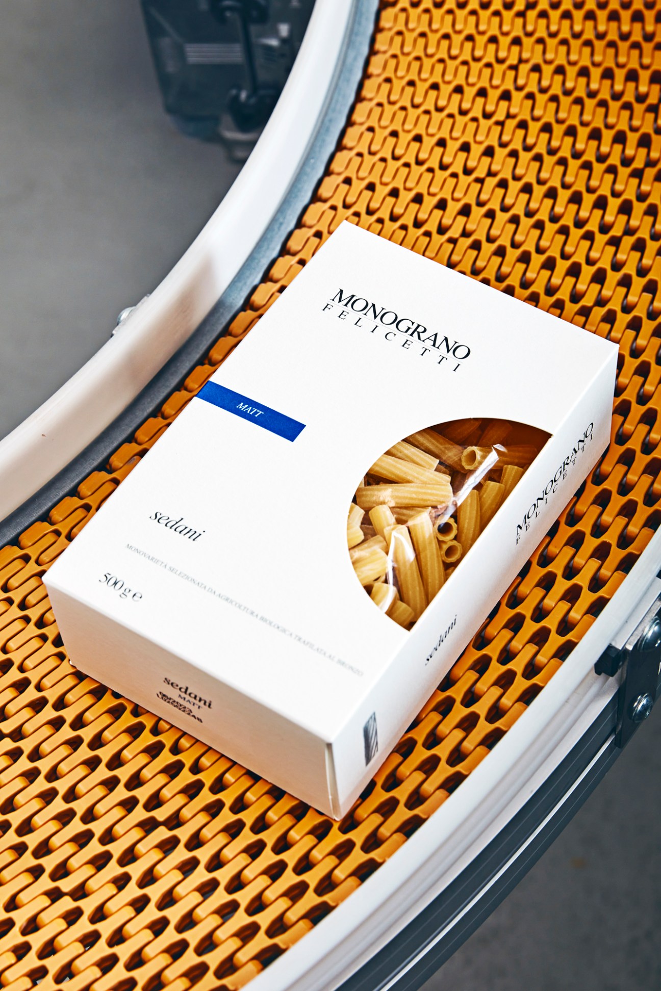 Felicetti Monograno pasta package showing sedani pasta through window, sitting on woven chair