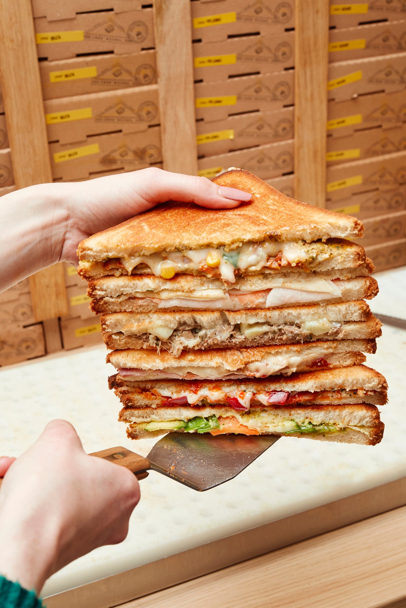 Six different croque monsieur sandwiches stacked and displayed showing variety of fillings