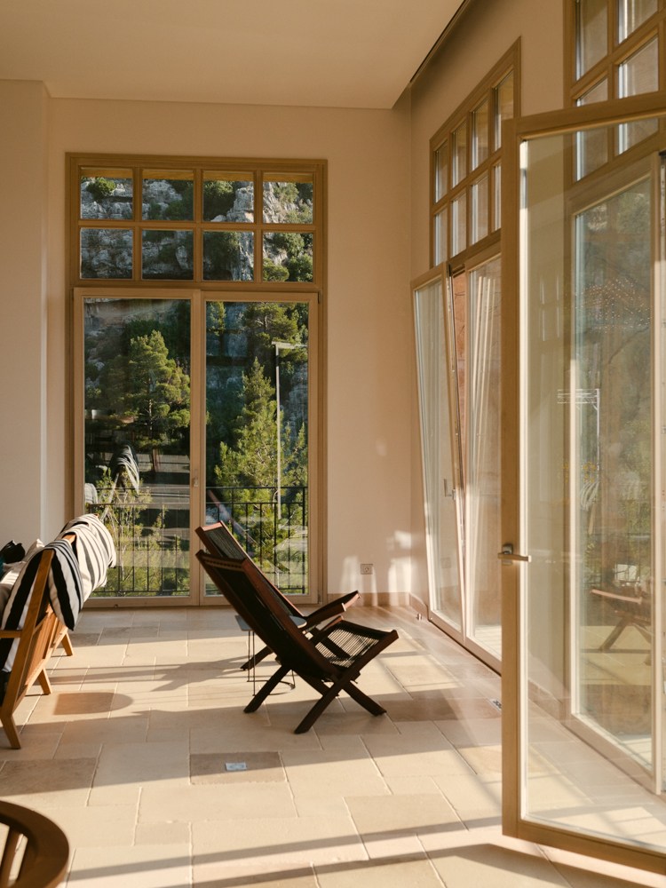 Sunlit interior space with wooden folding chair and stone tile flooring that stays naturally cool in warm weather