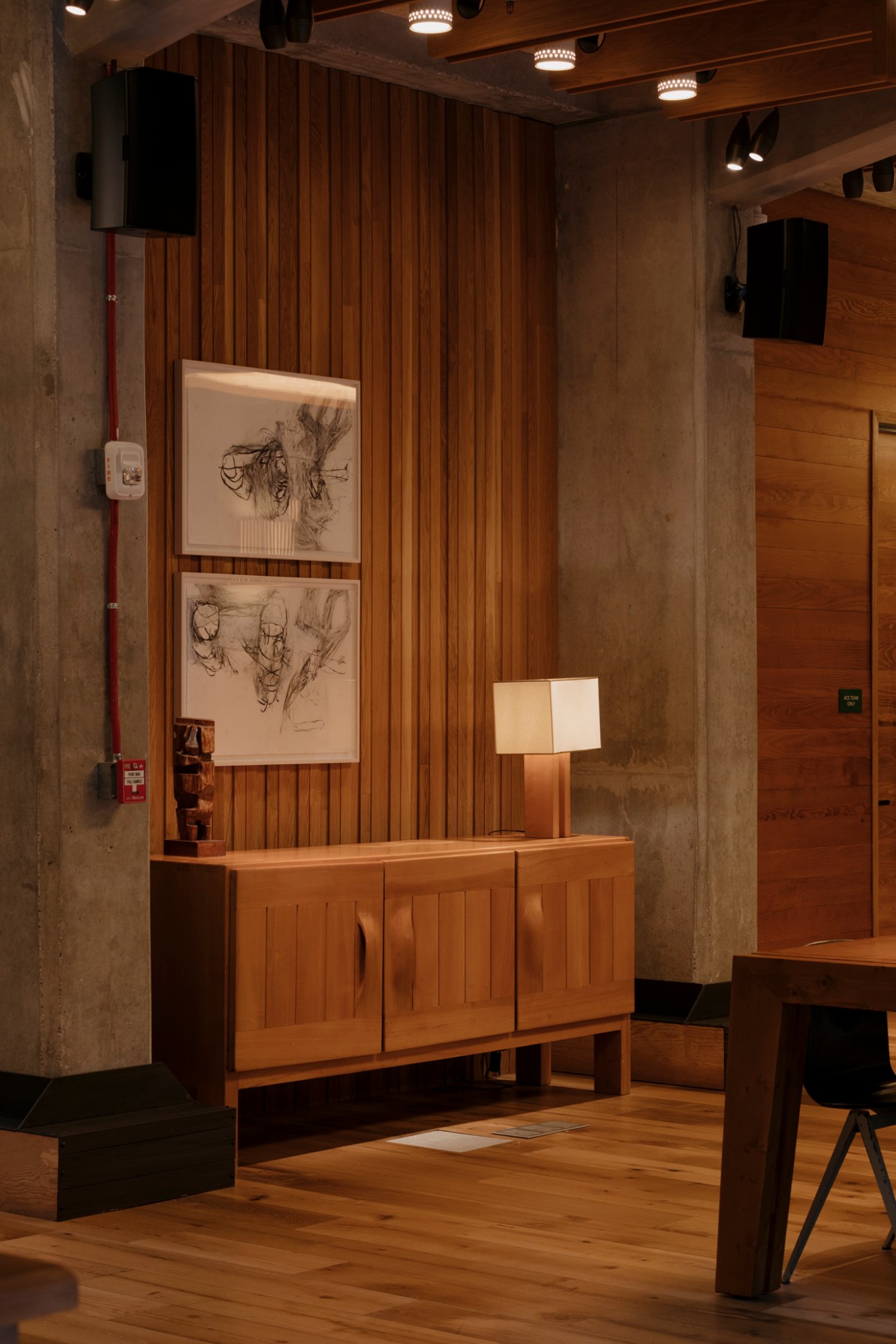 Modern wooden sideboard with illuminated artwork and table lamp in contemporary hotel interior