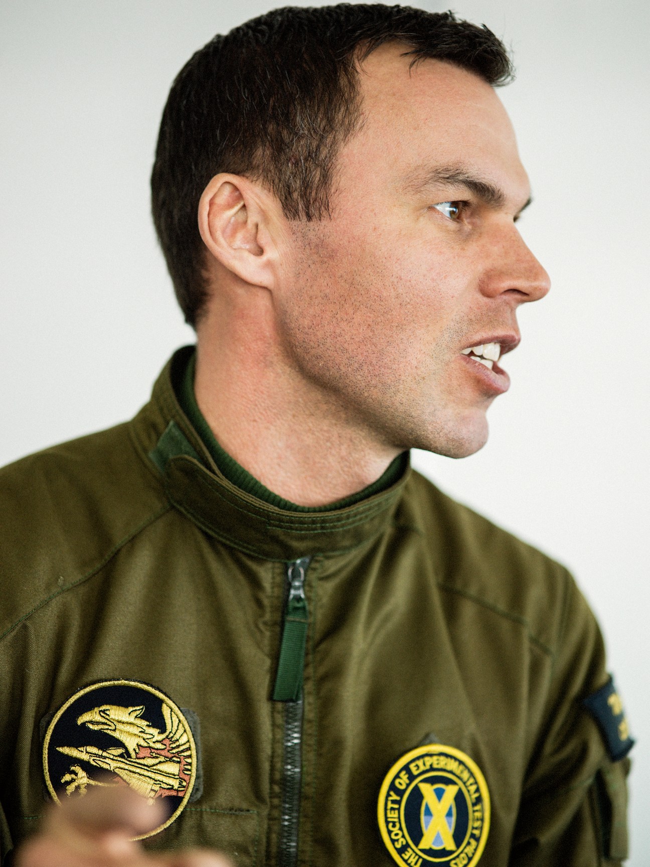 Marcus Wandt, Saab's chief test pilot, in profile wearing green flight suit with mission patches