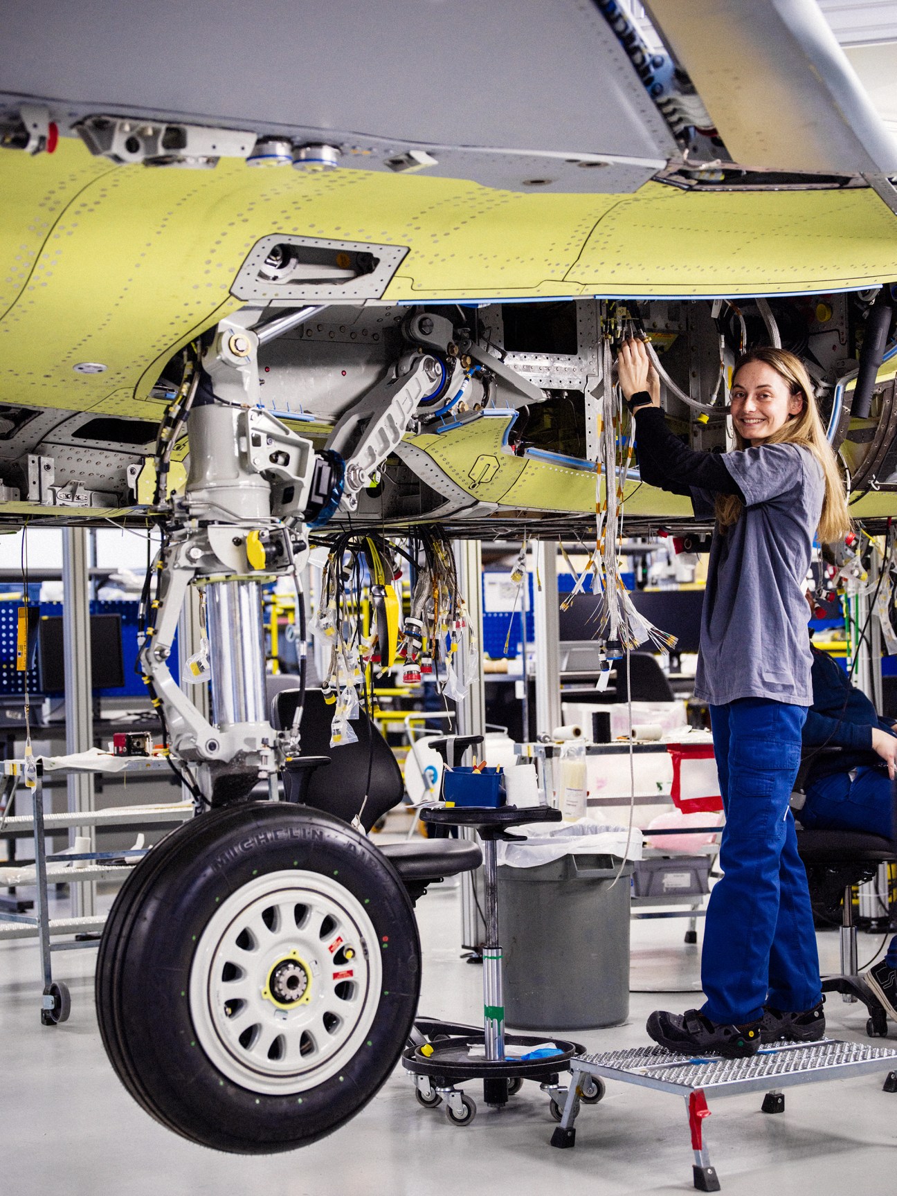 Saab technician carefully installing electrical wiring components in fighter jet assembly at the Linköping facility