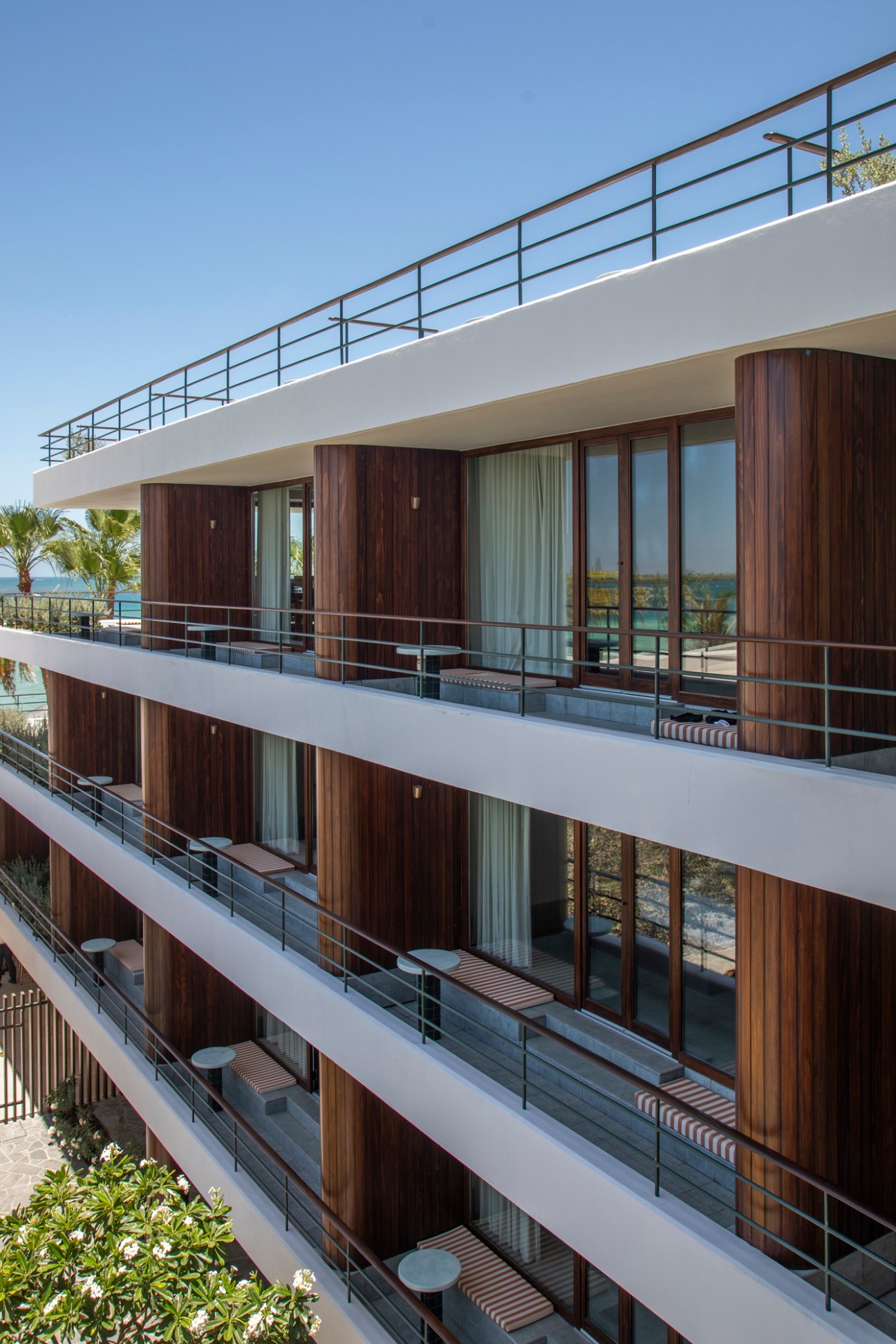 Ocean-view balconies at Baja Club with wood-panelled walls and striped seating overlooking the coastal landscape.