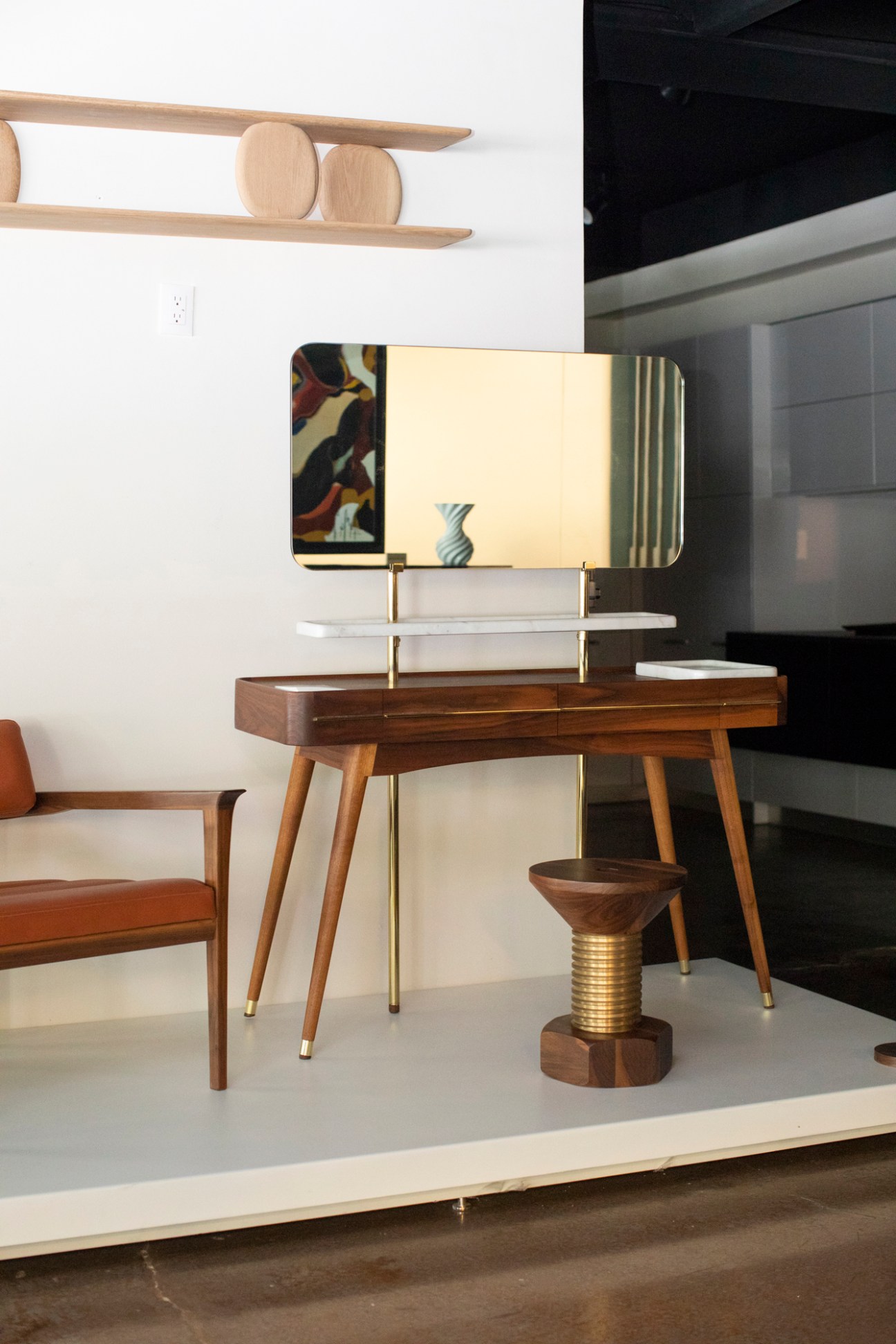 Joel Escalona sitting in his Mexico City studio with wooden furniture pieces from the Noviembre collection