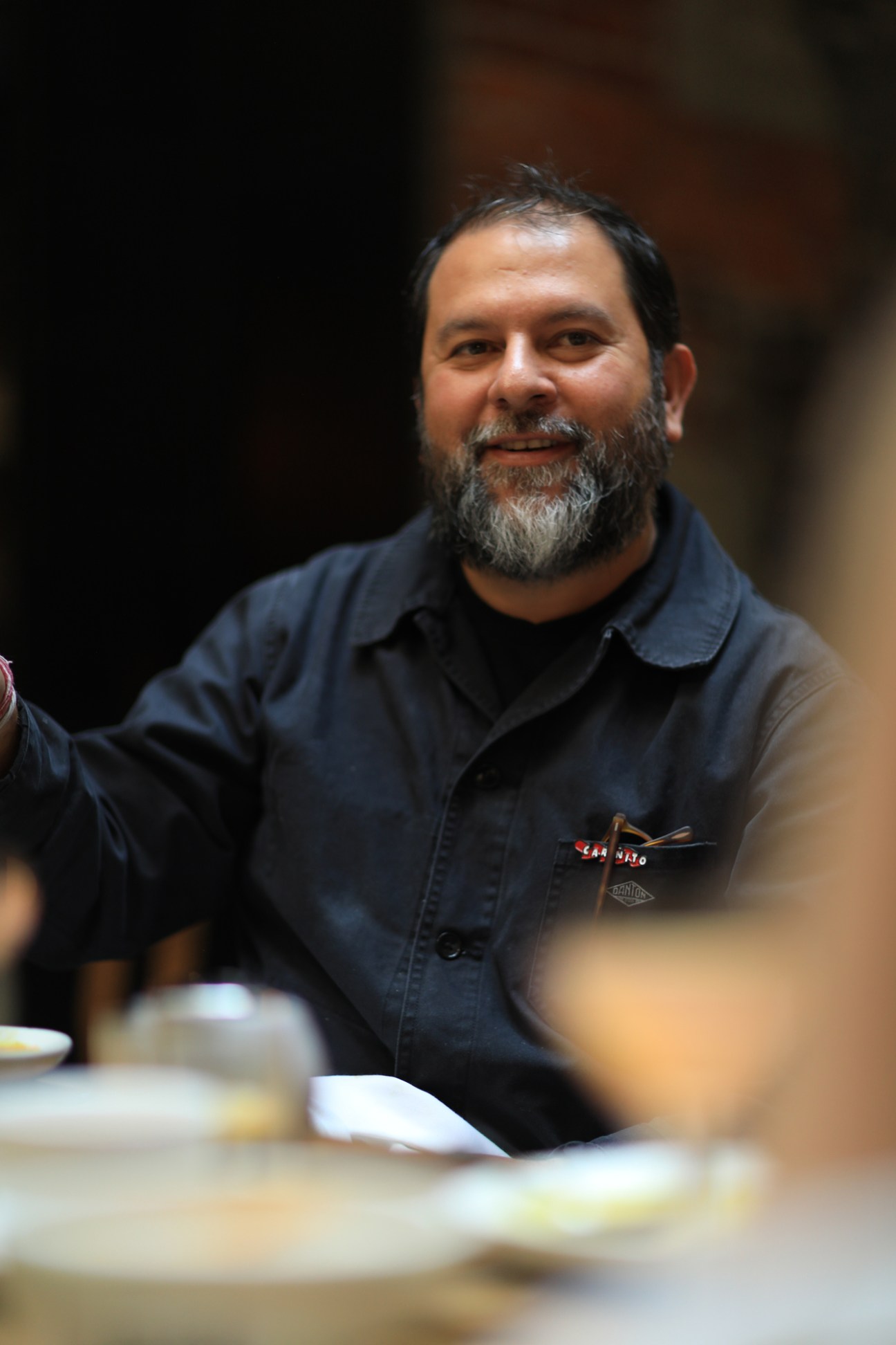 Enrique Olvera, chef and restaurateur, seated at a dining table during the round-table discussion.
