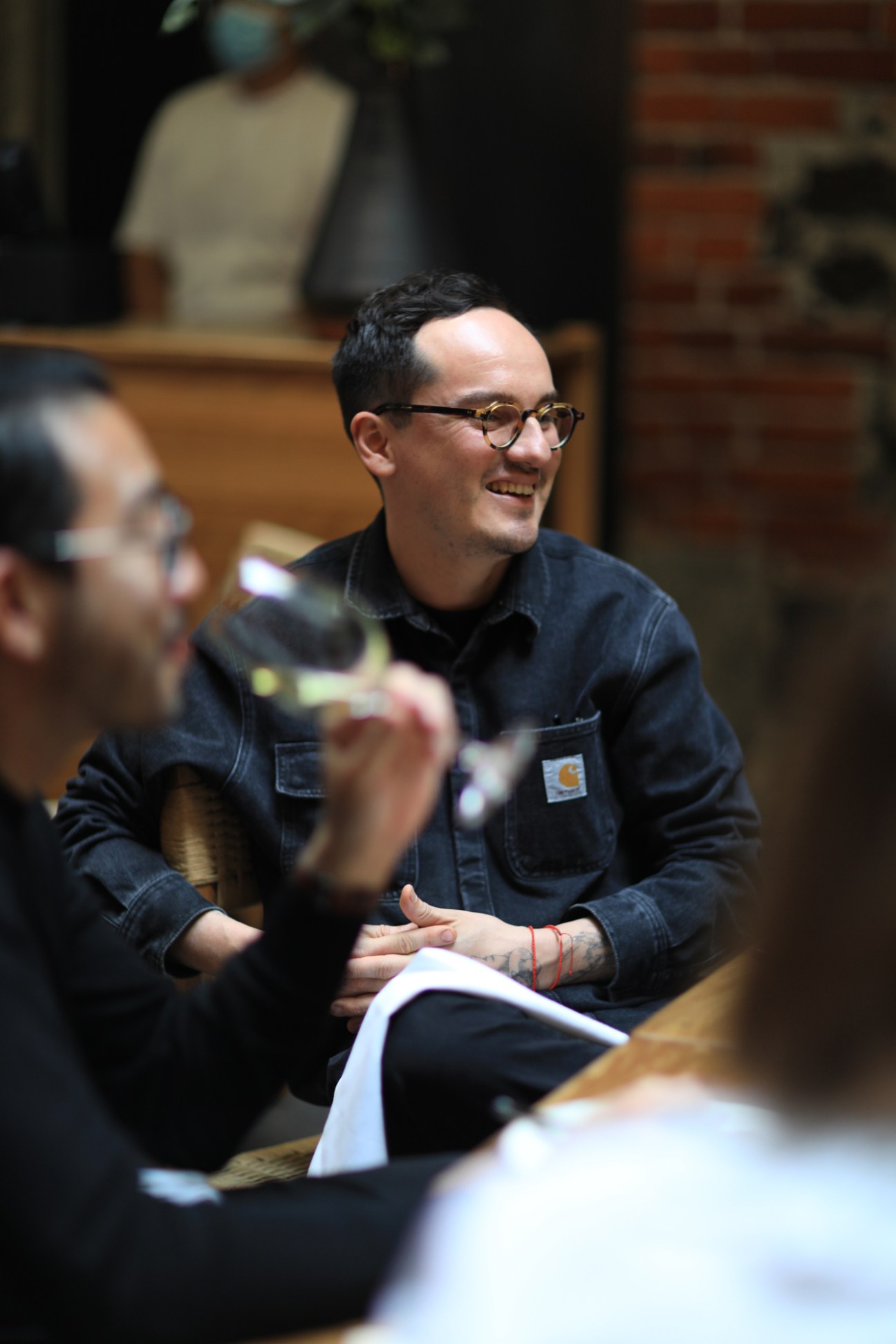 Chef Lucho Martínez smiling during a roundtable discussion at Caracol de Mar in Mexico City.