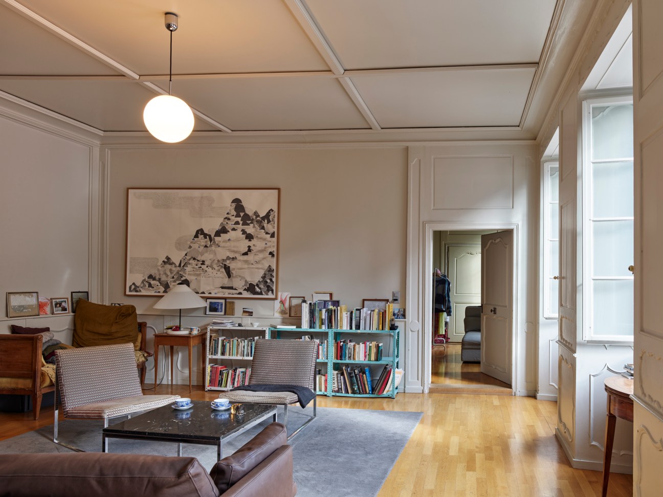 Interior view showing a painting by Benjamin Deken on the wall and a Vico Magistretti table lamp