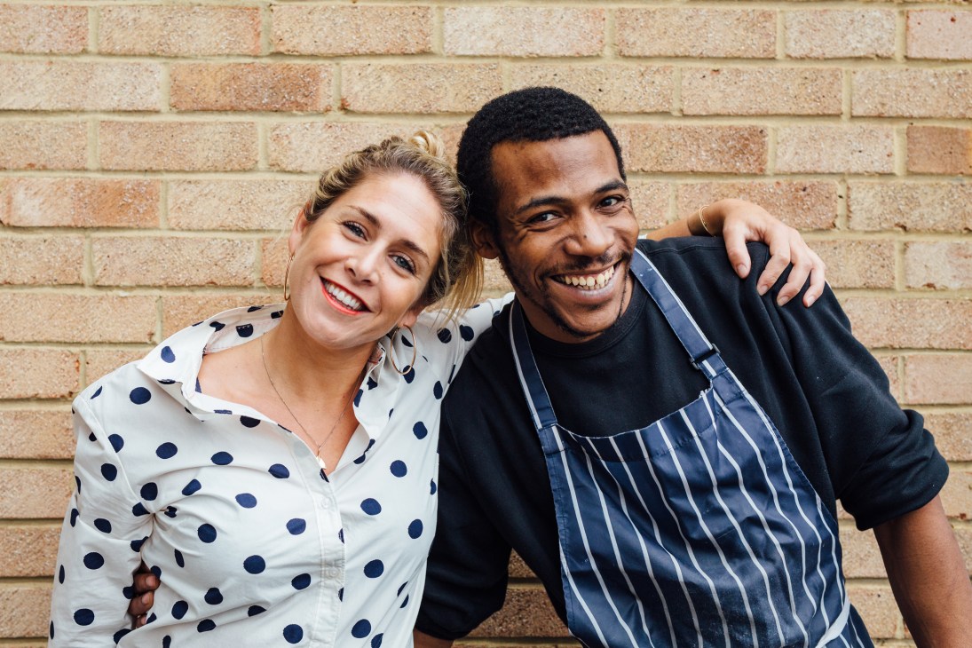 Alex Head and colleague from Social Pantry smiling together against brick wall