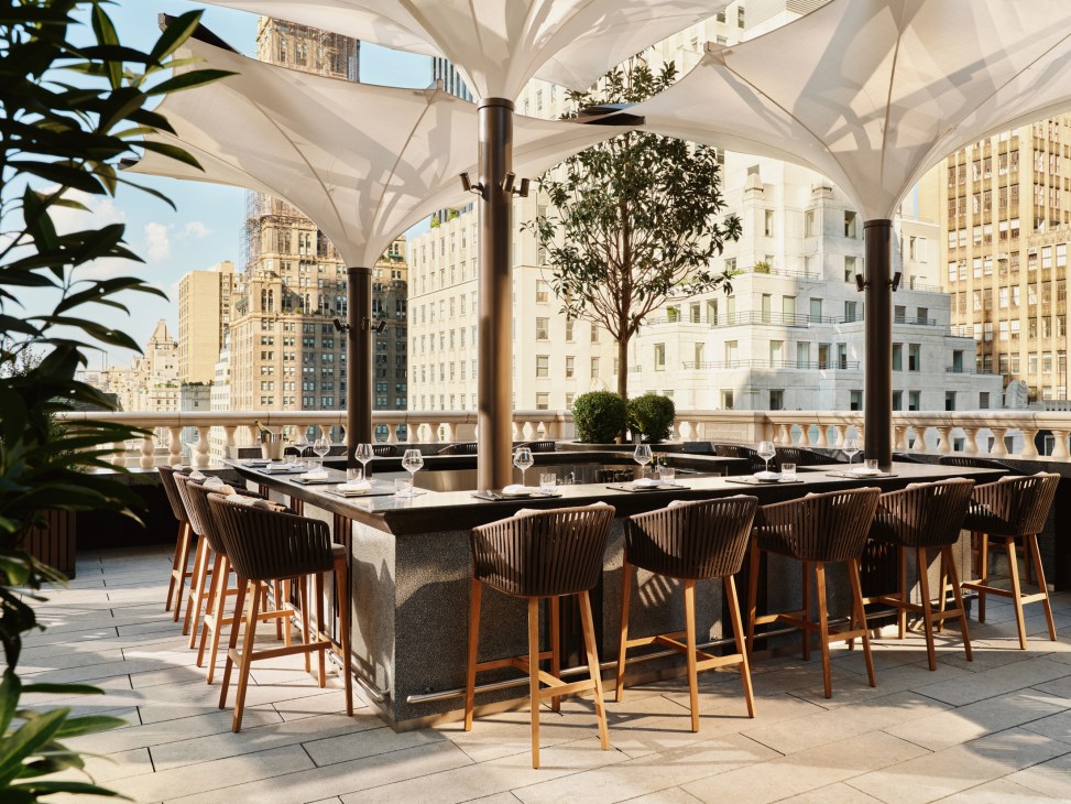 Aman New York's rooftop bar with outdoor seating overlooking Manhattan skyline and urban architecture