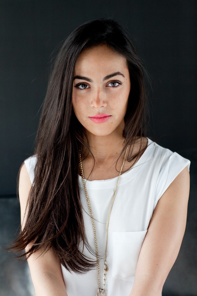 Amina Belouizdad Porter, CEO of PS, photographed in professional attire, professional headshot of a woman with long dark hair wearing a white sleeveless top and gold chain necklace