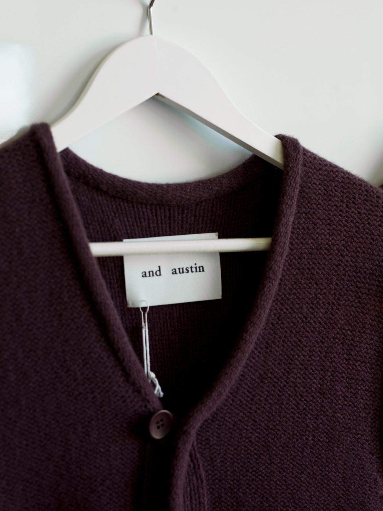 Close-up of a burgundy wool cardigan showing Italian yarn construction and fabric texture