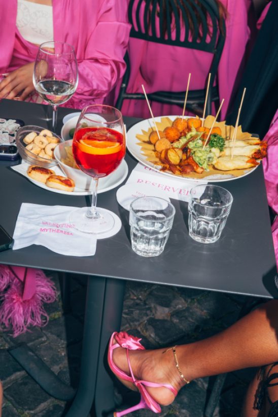 People enjoying aperitifs at an elegant Roman bar with outdoor seating overlooking a historic piazza