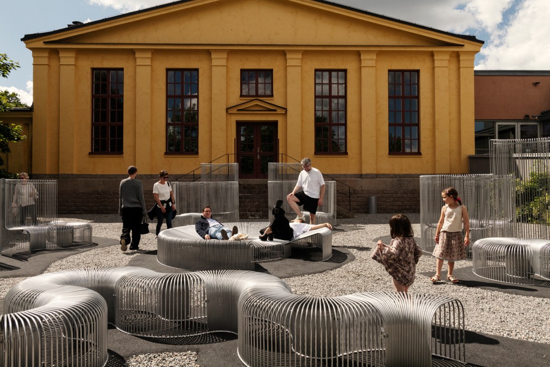 Close-up view of the ribbed steel public furniture installation at Arkdes museum garden