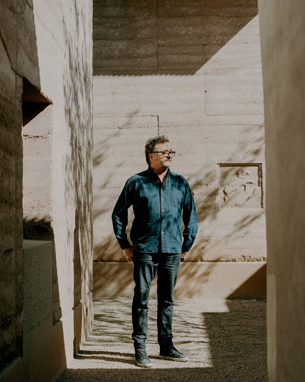 Architect Rick Joy standing in concrete corridor with natural lighting at his Tucson studio