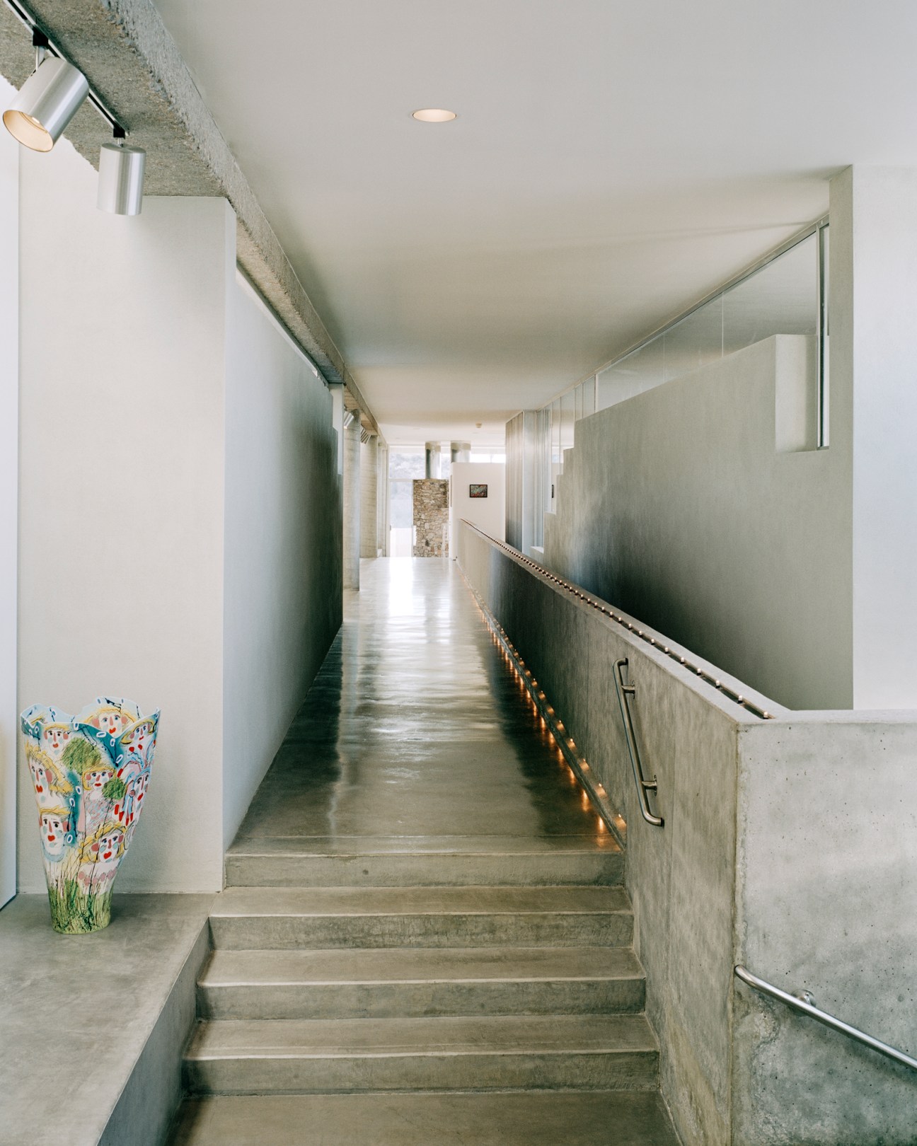 Concrete staircase with handrail and integrated lighting in modernist interior