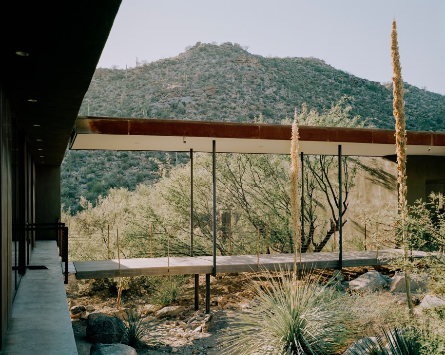 Post-tensioned concrete walkway at the Levin Residence connecting building modules over natural desert landscape