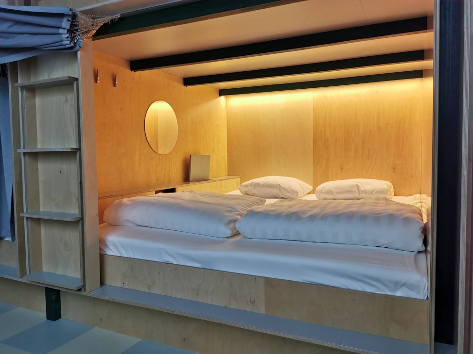 Modern capsule hotel interior showing rows of minimalist sleeping pods