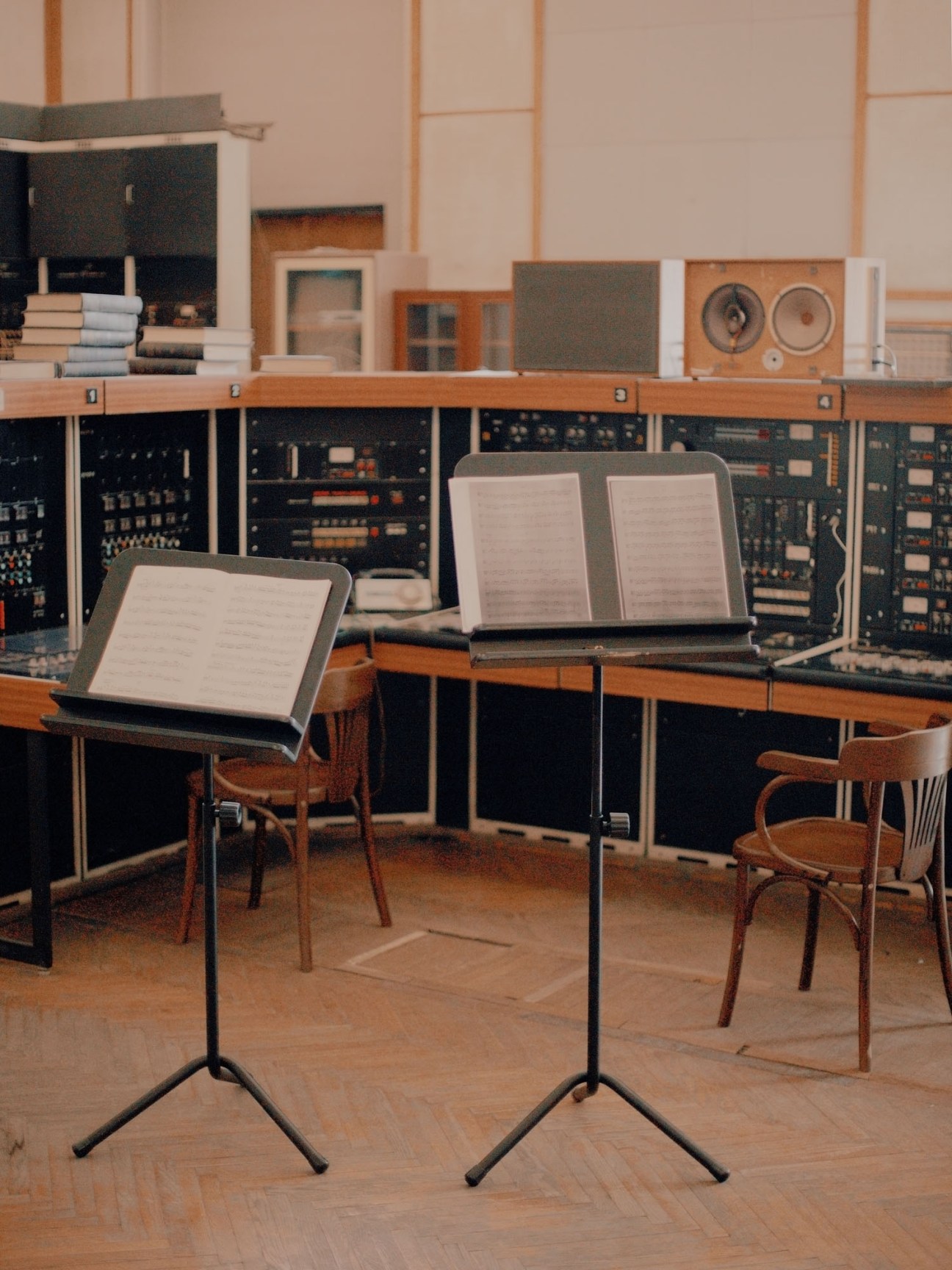 Large rehearsal room at Dom Radio with high ceilings, vintage audio equipment, music stands and wooden chairs