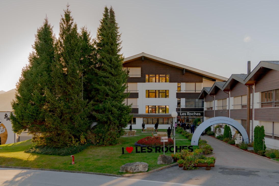 Students walking across the snow-covered campus of Les Roches International School of Hotel Management