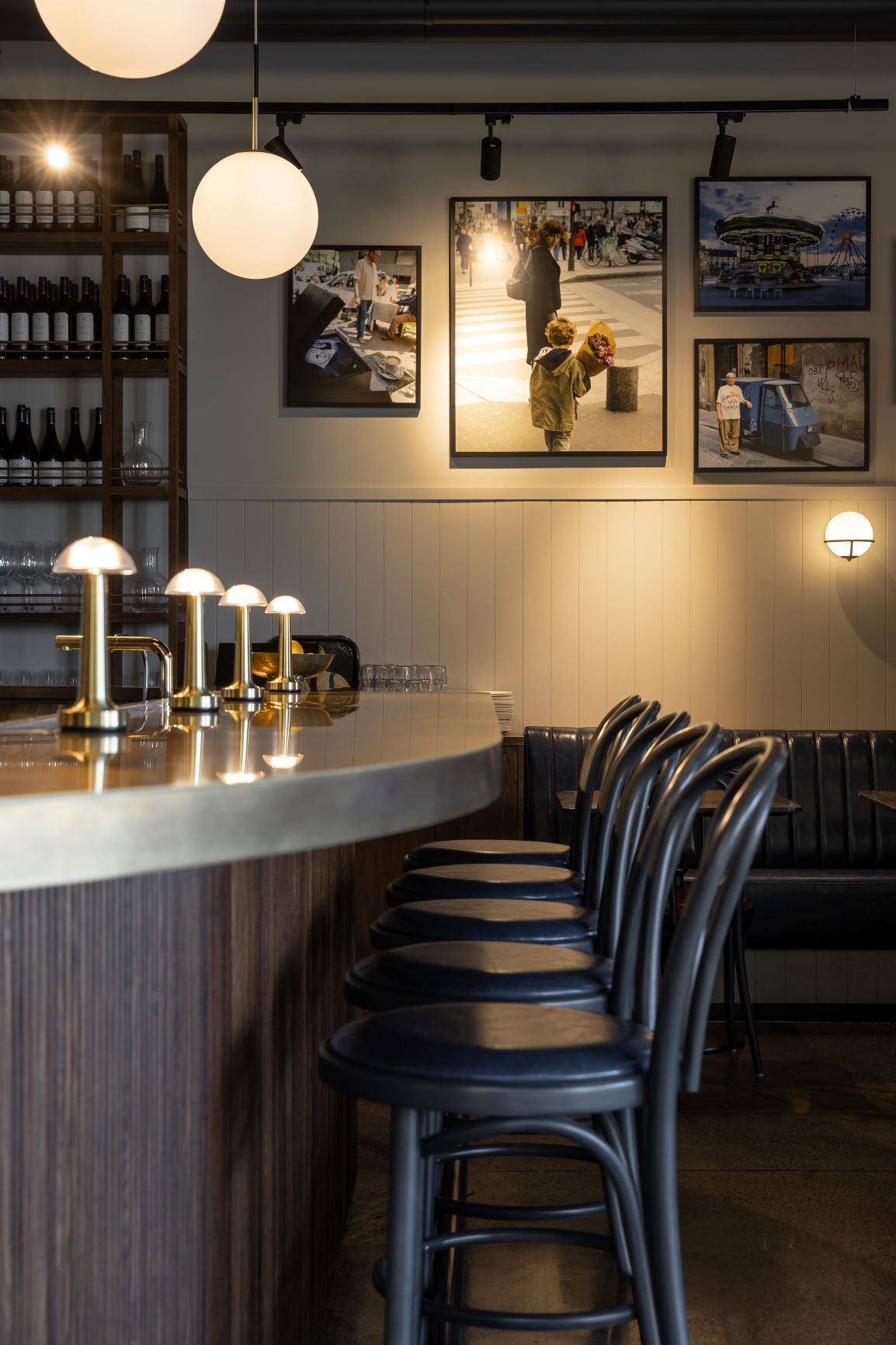 Modern bar interior with pendant lights, wine shelves, and black chairs at Mary's restaurant in Hawke's Bay