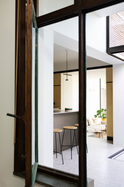 Open-plan living area with modern furniture and large windows allowing natural light to flood the space